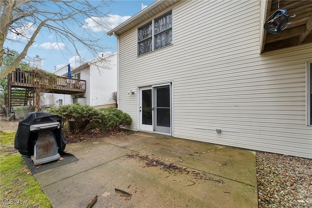 back of property featuring a patio area and a wooden deck