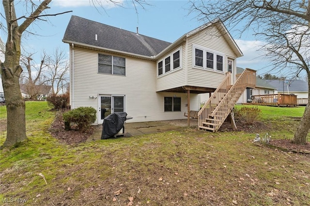 back of house featuring a wooden deck and a yard