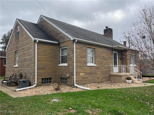 view of side of home with a yard