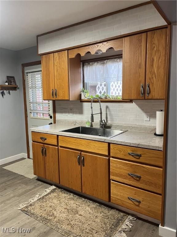 kitchen with hardwood / wood-style floors, decorative backsplash, and sink