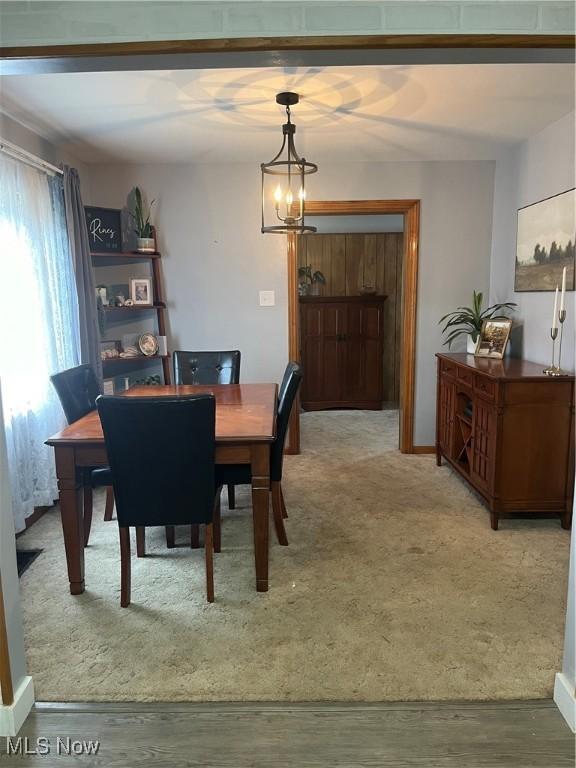 dining space featuring carpet flooring and a notable chandelier