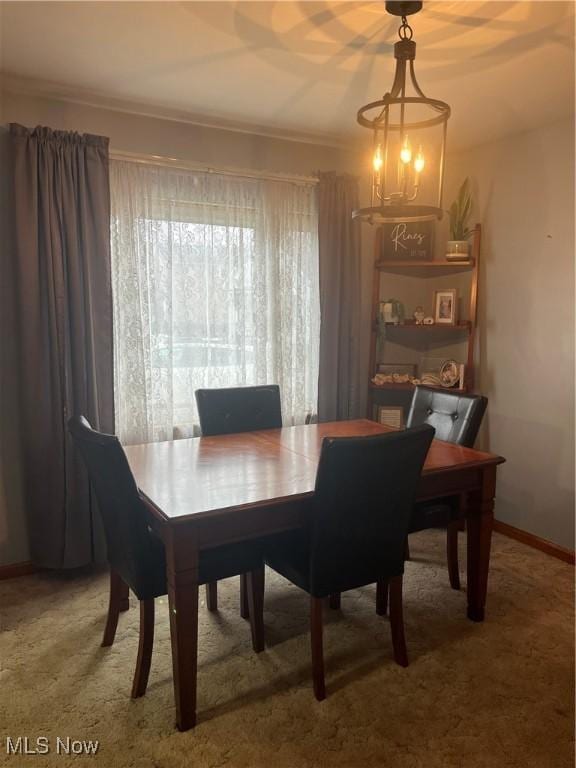 dining area featuring carpet and a chandelier