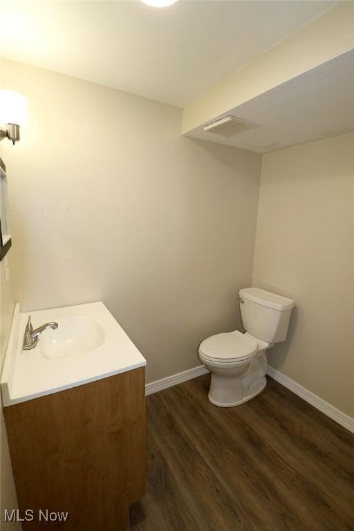 bathroom featuring vanity, toilet, and wood-type flooring