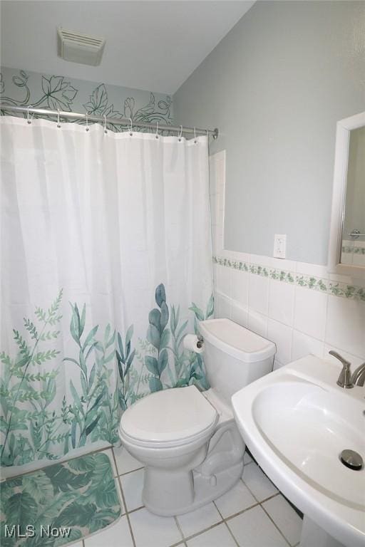 bathroom featuring sink, tile patterned flooring, a shower with shower curtain, toilet, and tile walls