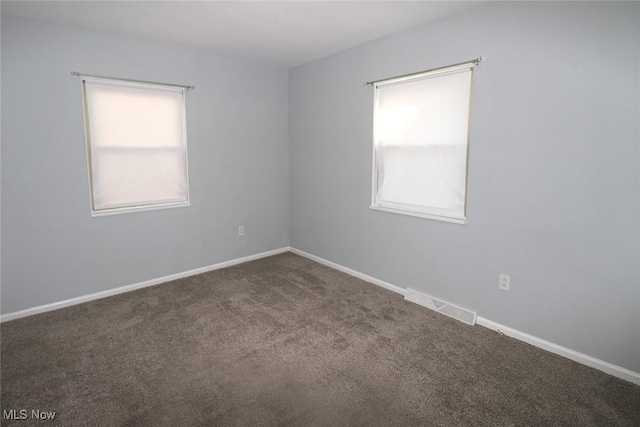 carpeted spare room featuring plenty of natural light