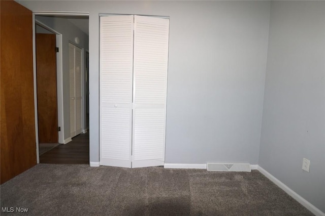 unfurnished bedroom with dark carpet