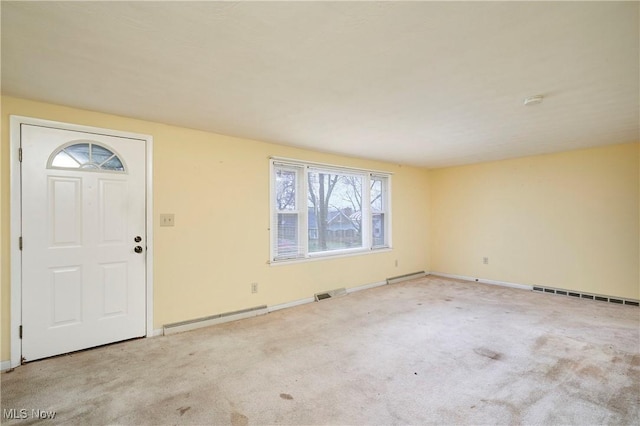 carpeted entryway with a baseboard heating unit