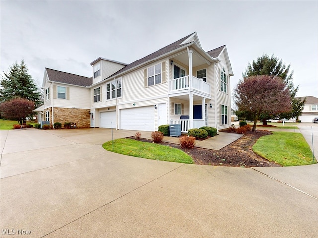 view of front of home with a balcony, cooling unit, covered porch, and a garage