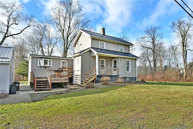 rear view of house with a porch, a yard, and a deck