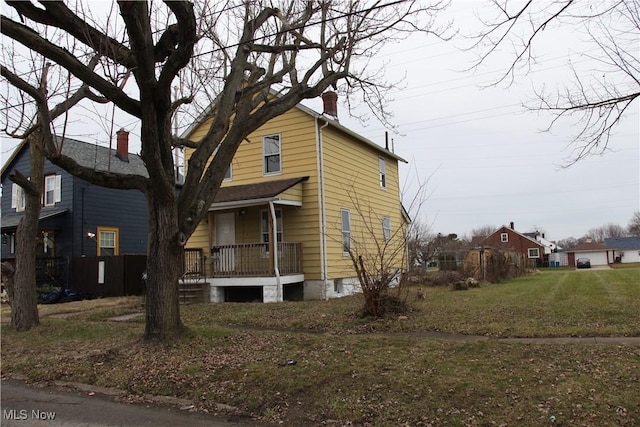 view of side of property with a porch and a yard