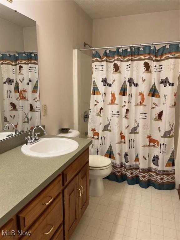 bathroom with a shower with curtain, toilet, and vanity