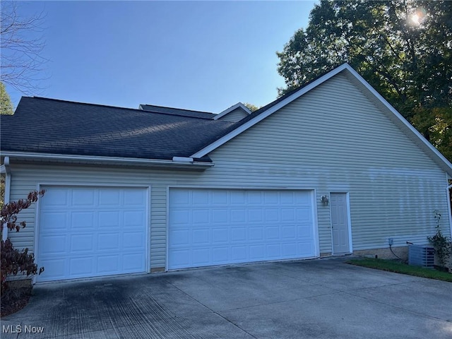 view of side of property with central AC unit and a garage