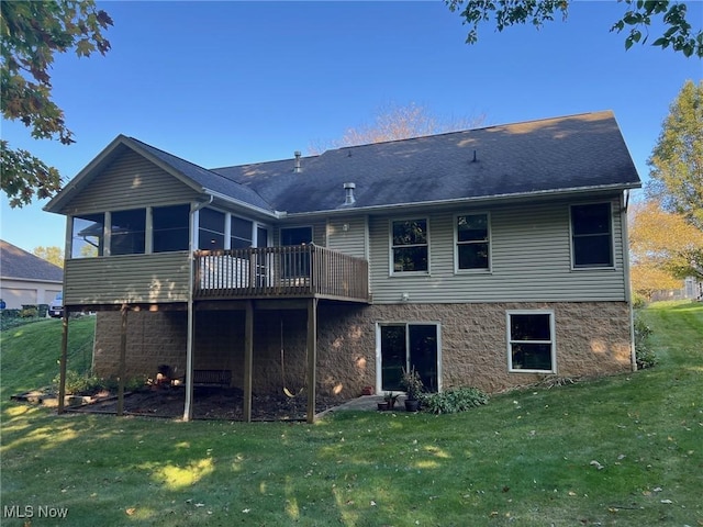 rear view of property featuring a wooden deck, a yard, and a sunroom