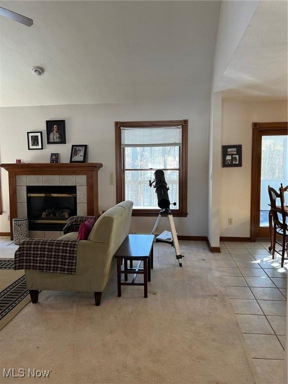 tiled living room featuring plenty of natural light and a fireplace