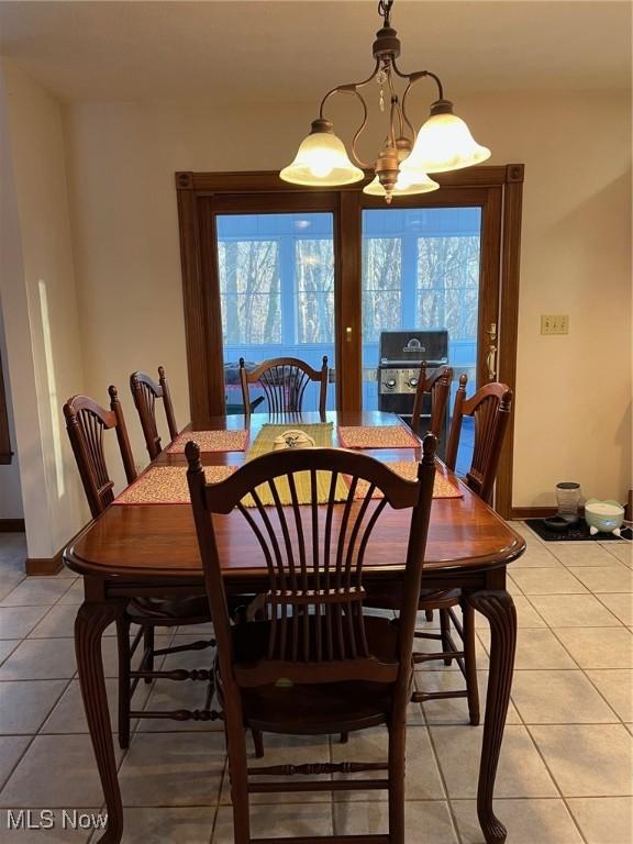 dining room with plenty of natural light, tile patterned flooring, and an inviting chandelier