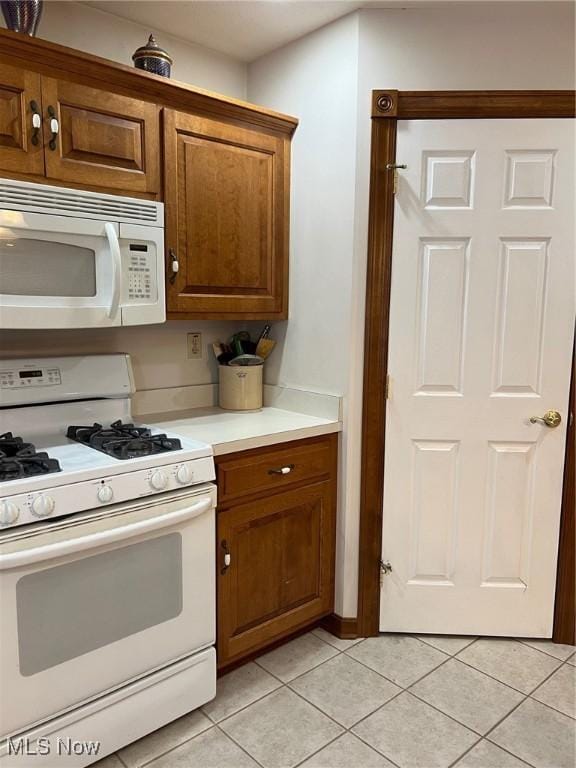 kitchen featuring white appliances and light tile patterned floors