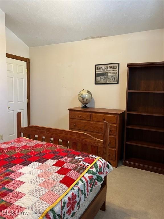 carpeted bedroom with vaulted ceiling