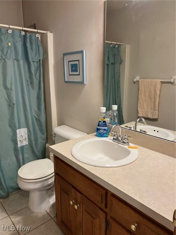 full bathroom featuring vanity, toilet, shower / bath combination with curtain, and tile patterned flooring