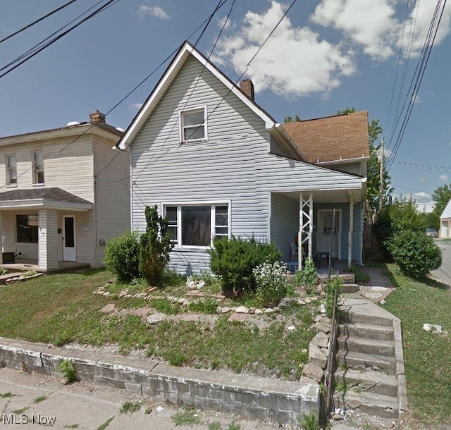 view of front of home with a front yard and a porch