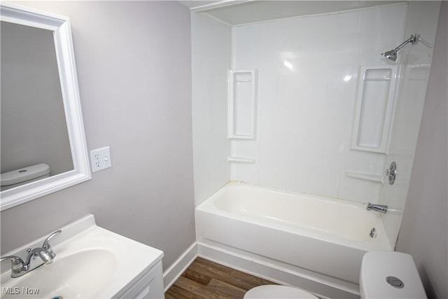 full bathroom with bathing tub / shower combination, toilet, vanity, and hardwood / wood-style flooring