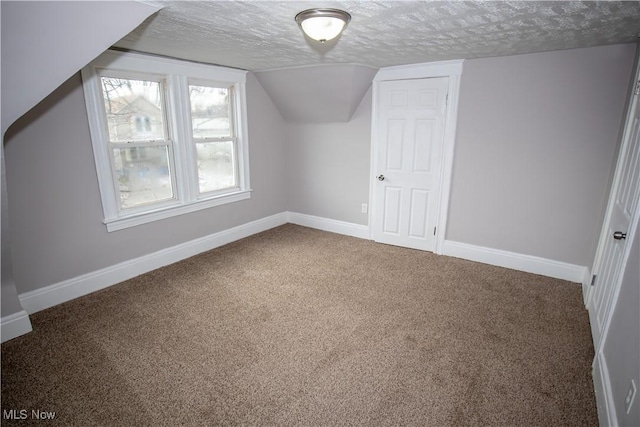 additional living space with a textured ceiling, carpet floors, and lofted ceiling