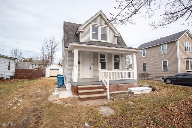 bungalow featuring a garage, covered porch, and an outbuilding