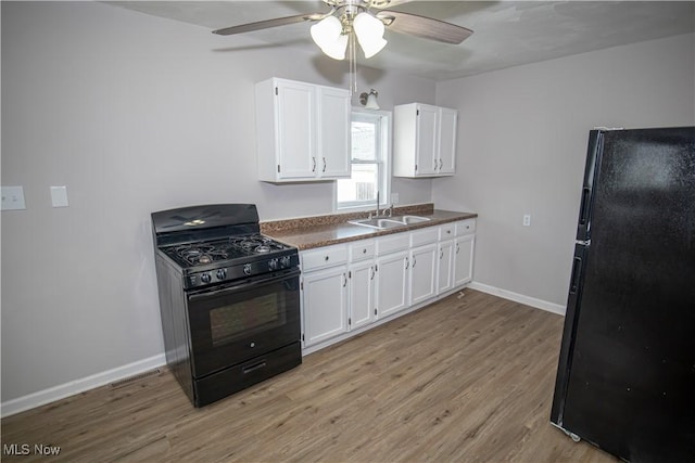 kitchen with ceiling fan, sink, black appliances, light hardwood / wood-style flooring, and white cabinetry