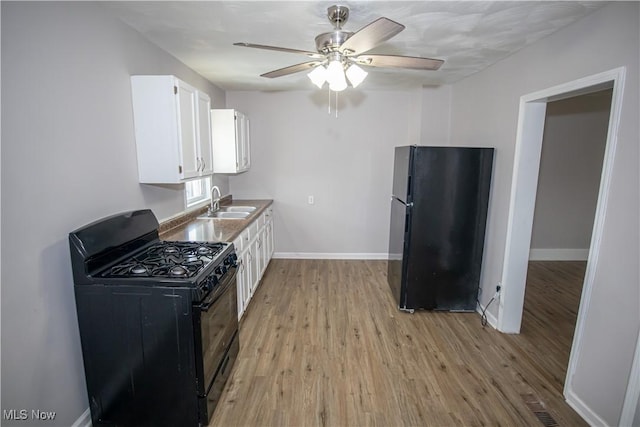 kitchen featuring white cabinets, sink, light hardwood / wood-style flooring, and black appliances