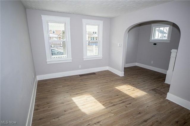 empty room featuring dark wood-type flooring and a textured ceiling