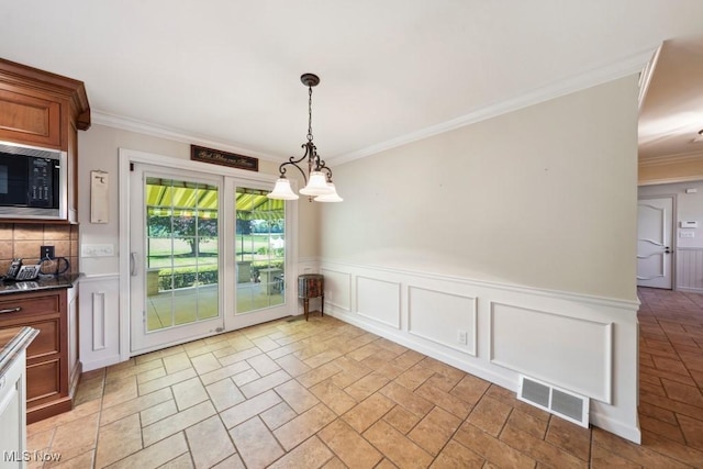 unfurnished dining area with a chandelier and ornamental molding