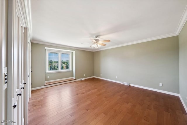 empty room featuring hardwood / wood-style floors, ceiling fan, and ornamental molding