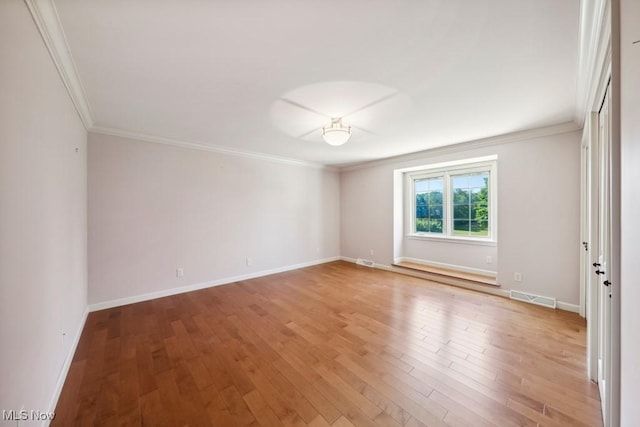 spare room with wood-type flooring and ornamental molding