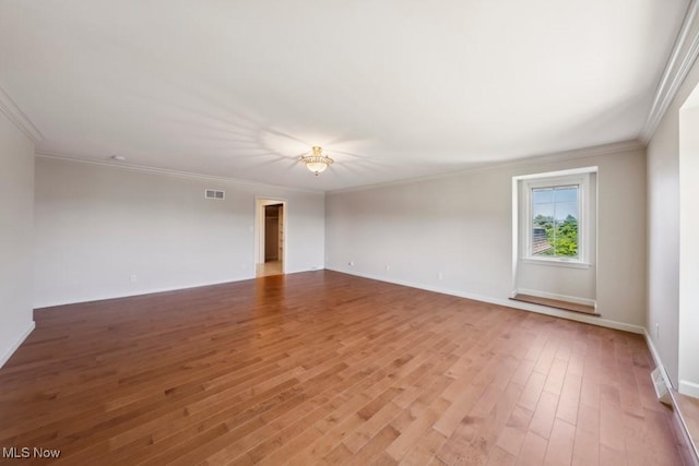 unfurnished room with hardwood / wood-style floors and crown molding