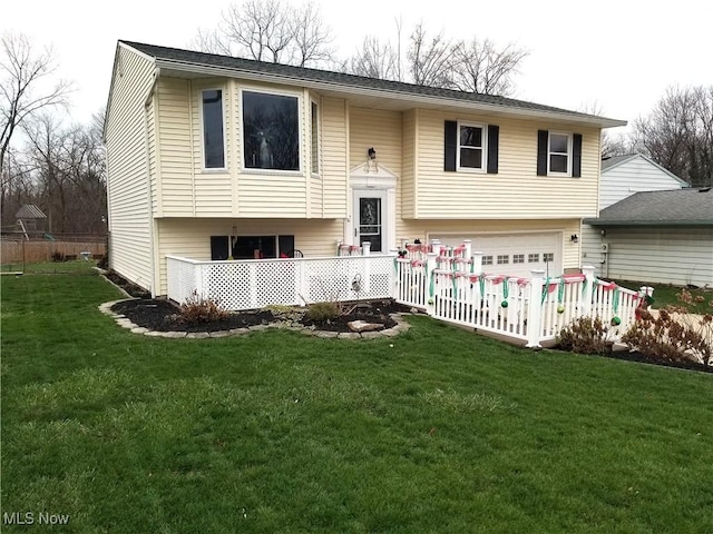 raised ranch with a garage and a front lawn