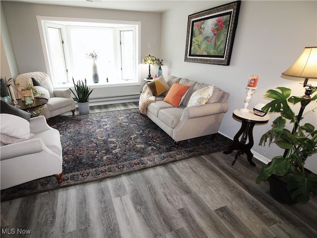 living area with a baseboard radiator, baseboards, and wood finished floors