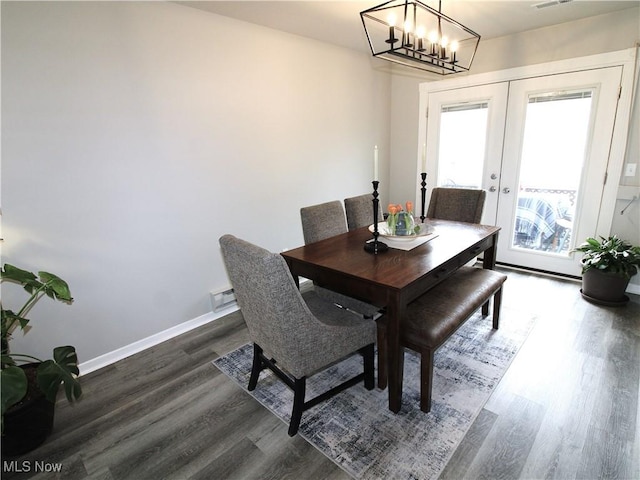 dining space with french doors, visible vents, dark wood-type flooring, a chandelier, and baseboards