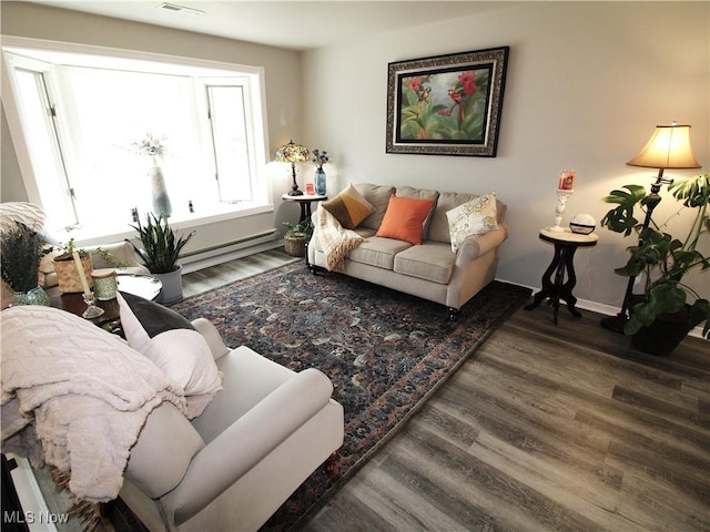 living area with wood finished floors, visible vents, and baseboards