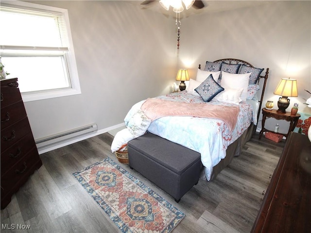 bedroom featuring a ceiling fan, baseboards, a baseboard heating unit, and wood finished floors