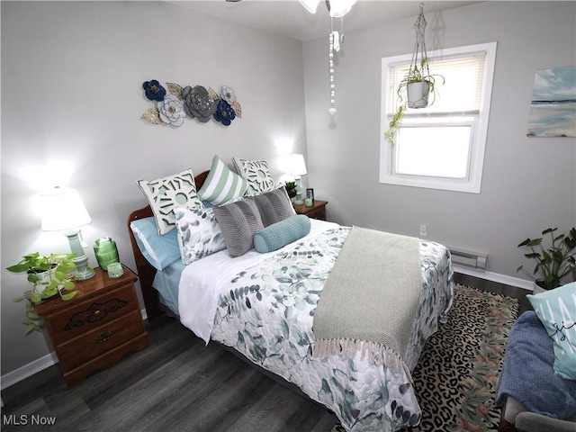 bedroom with visible vents, baseboards, and wood finished floors