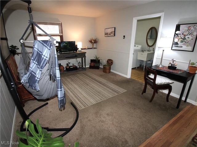 carpeted living room featuring wainscoting and a sink