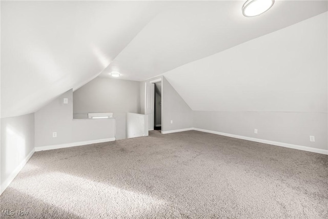 additional living space featuring carpet flooring and vaulted ceiling