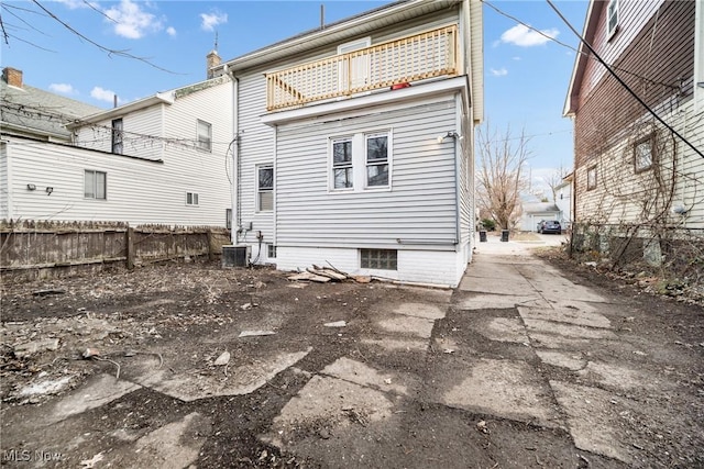 rear view of property featuring a balcony and central AC