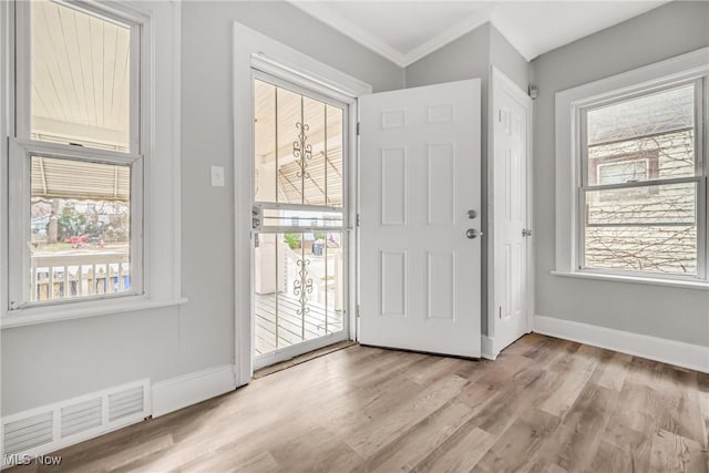 doorway featuring light hardwood / wood-style floors and crown molding