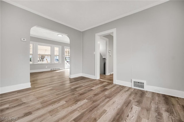 spare room featuring light hardwood / wood-style flooring and crown molding