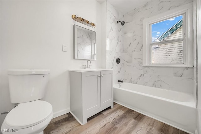 full bathroom with vanity, hardwood / wood-style flooring, toilet, and tiled shower / bath