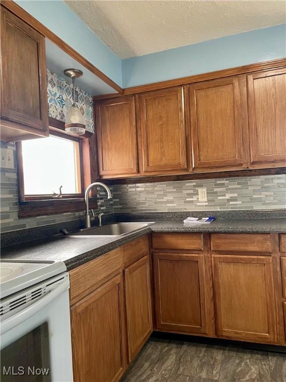 kitchen featuring a textured ceiling, sink, and tasteful backsplash