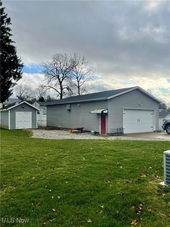 single story home with a garage, a shed, and a front yard