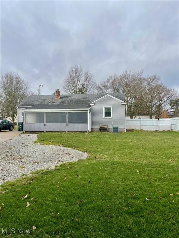 rear view of house with a yard and cooling unit