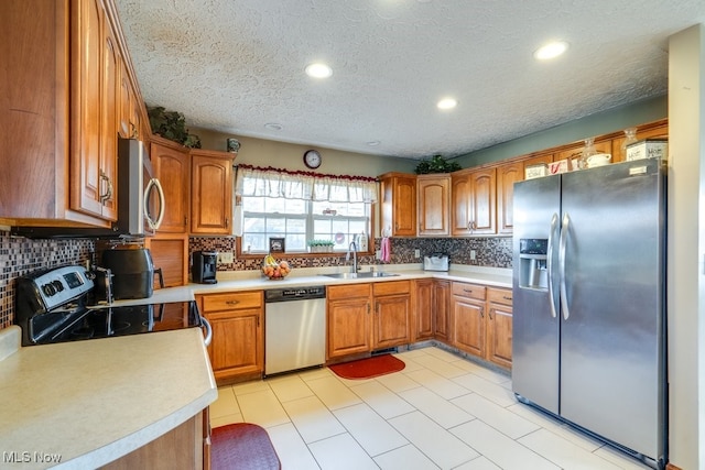 kitchen featuring a textured ceiling, sink, appliances with stainless steel finishes, and tasteful backsplash