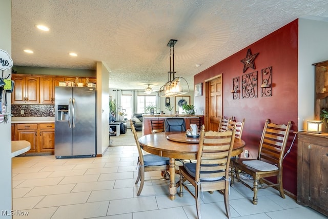 dining space featuring ceiling fan and a textured ceiling